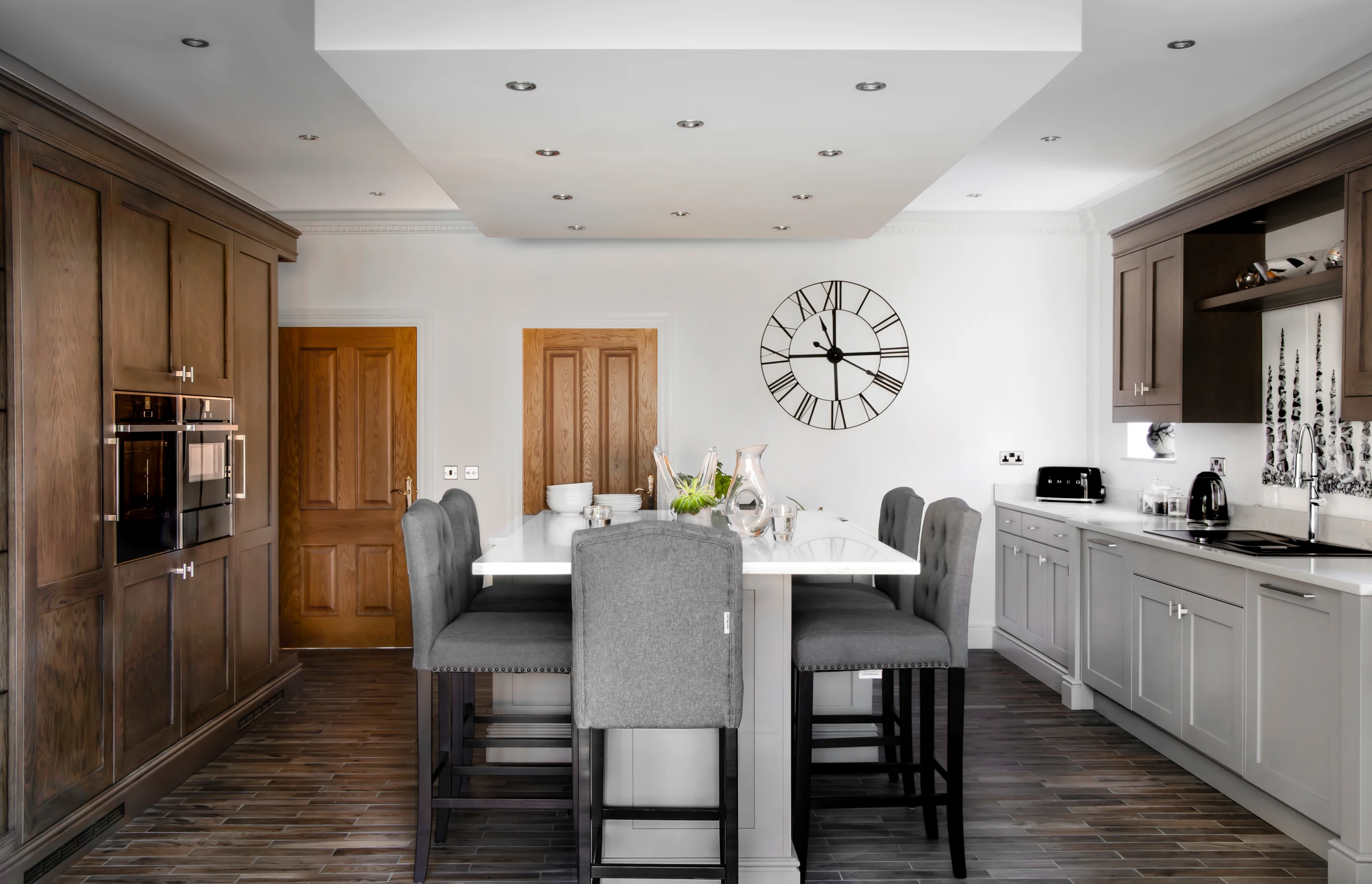 A Corinthian kitchen arranged around an island with full-height and painted cabinetry
