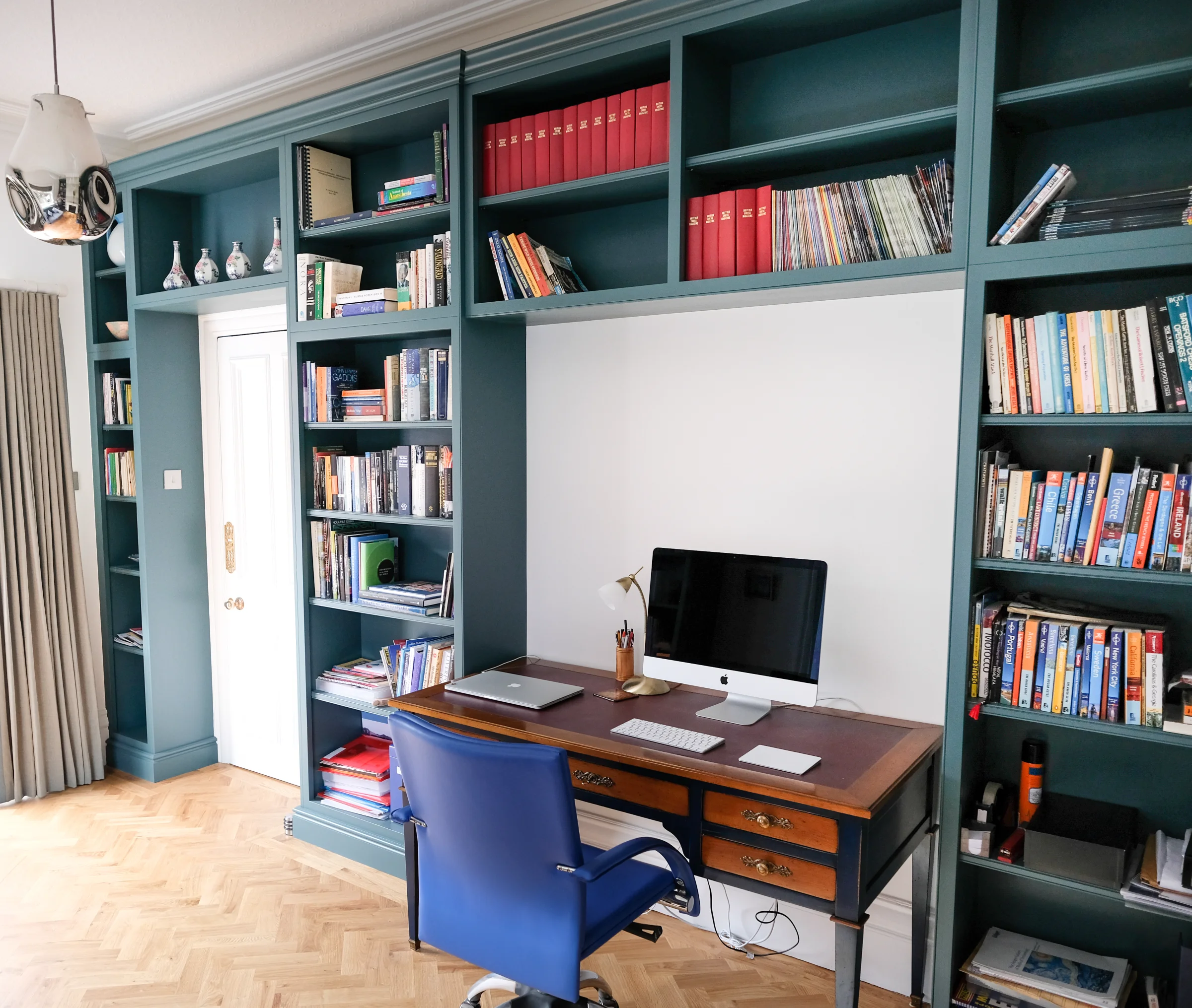 A fitted green study arranged around a desk and doorway